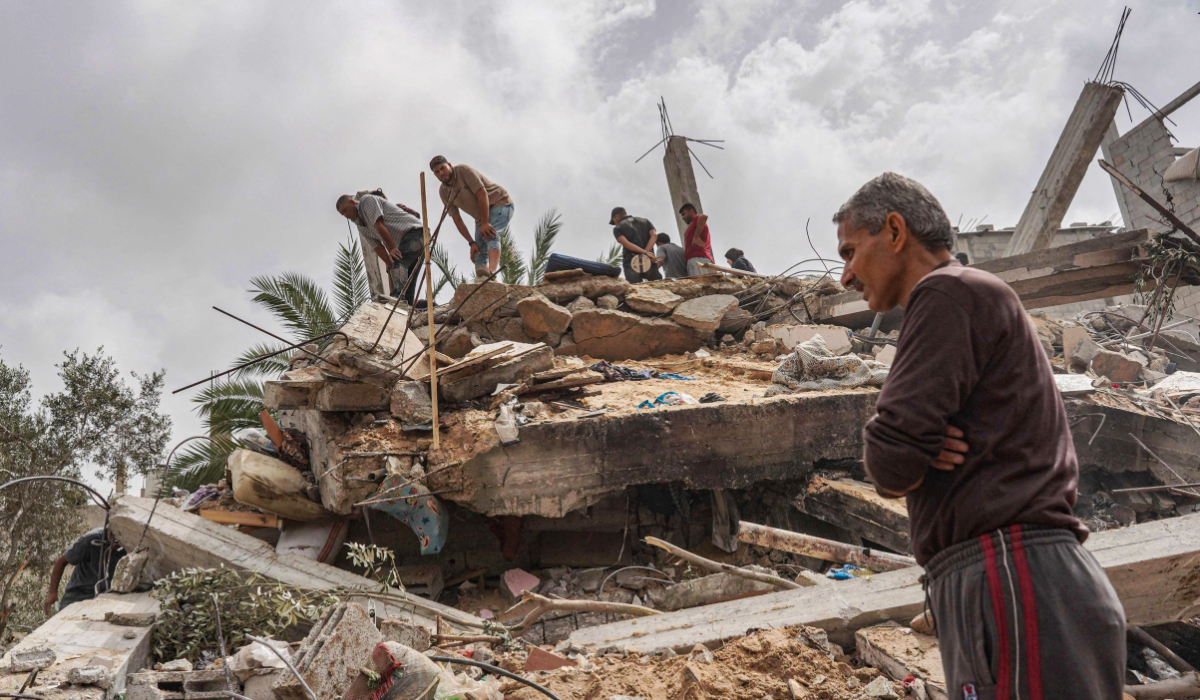 Palestinians check the rubble of a residential building destroyed in an Israeli strike in Al-Zawayda in the central Gaza Strip on May 11, 2024, amid the ongoing conflict between Israel and the Hamas movement. (AFP)