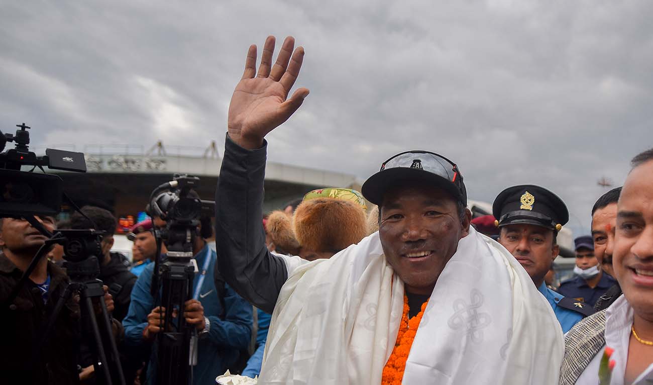 Nepali guide Kami Rita Sherpa who reached the top of Mount Everest on May 23, 2023, for a record 28th time gestures to the crowd upon arriving at the Tribhuvan airport in Kathmandu on May 25, 2023. (AFP/File)