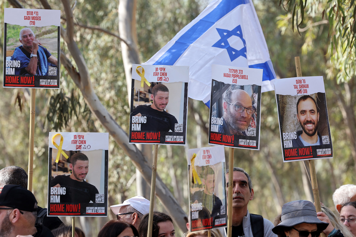 People hold portraits of hostages Gadi Moses, Itay Chen, Nadav Popplewell and Tal Shoham held in Gaza since the October 7 attacks. (File/AFP)