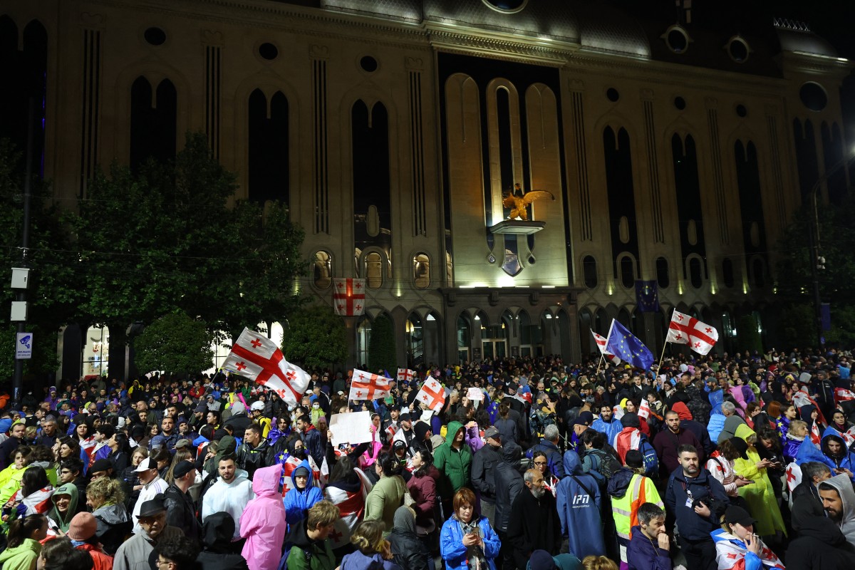 Protesters wave the Georgian and EU flags as they gather outside parliament during a rally against the controversial "foreign influence" bill in Tbilisi on May 12, 2024. (AFP)