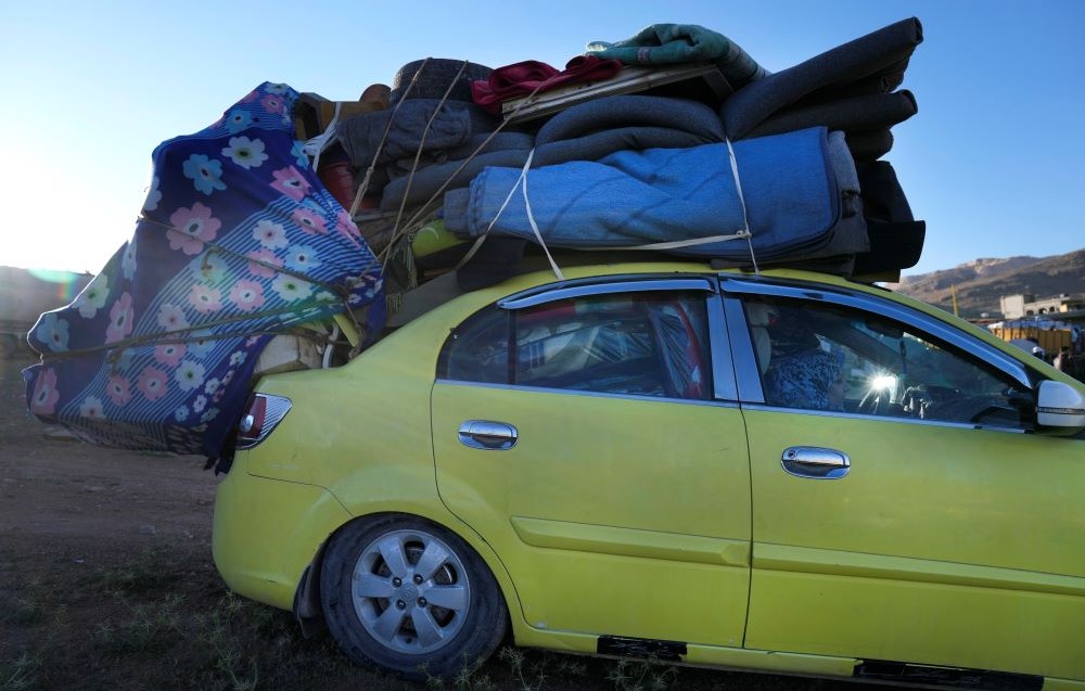 A Syrian refugee woman sits inside a car, as she prepares to go back home to Syria as a part of a voluntary return, in the eastern Lebanese border town of Arsal, Tuesday, May 14, 2024. (AP Photo)