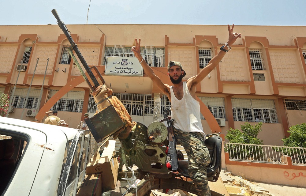 Four years after a UN- brokered ‘permanent ceasefire,’ violence between Libya’s various armed factions, main, below and bottom right, continues to undermine security. (AFP)