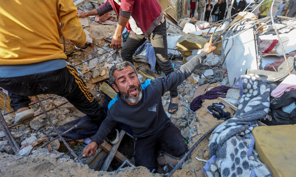 A Palestinian man reacts as he searches for casualties at the site of an Israeli strike on a house, amid the ongoing conflict between Israel and the Palestinian Islamist group Hamas, in Nuseirat refugee camp in the central Gaza Strip, May 14, 2024. (Reuters)