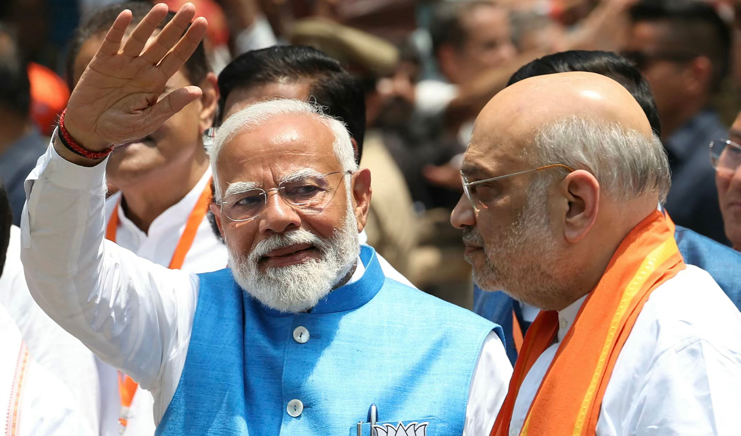 Indian Prime Minister Narendra Modi (L) waves to supporters next to India's Home Minister Amit Shah after filing his nomination papers to recontest the parliamentary seat in Varanasi on May 14, 2024, during the country's ongoing general election. (AFP)