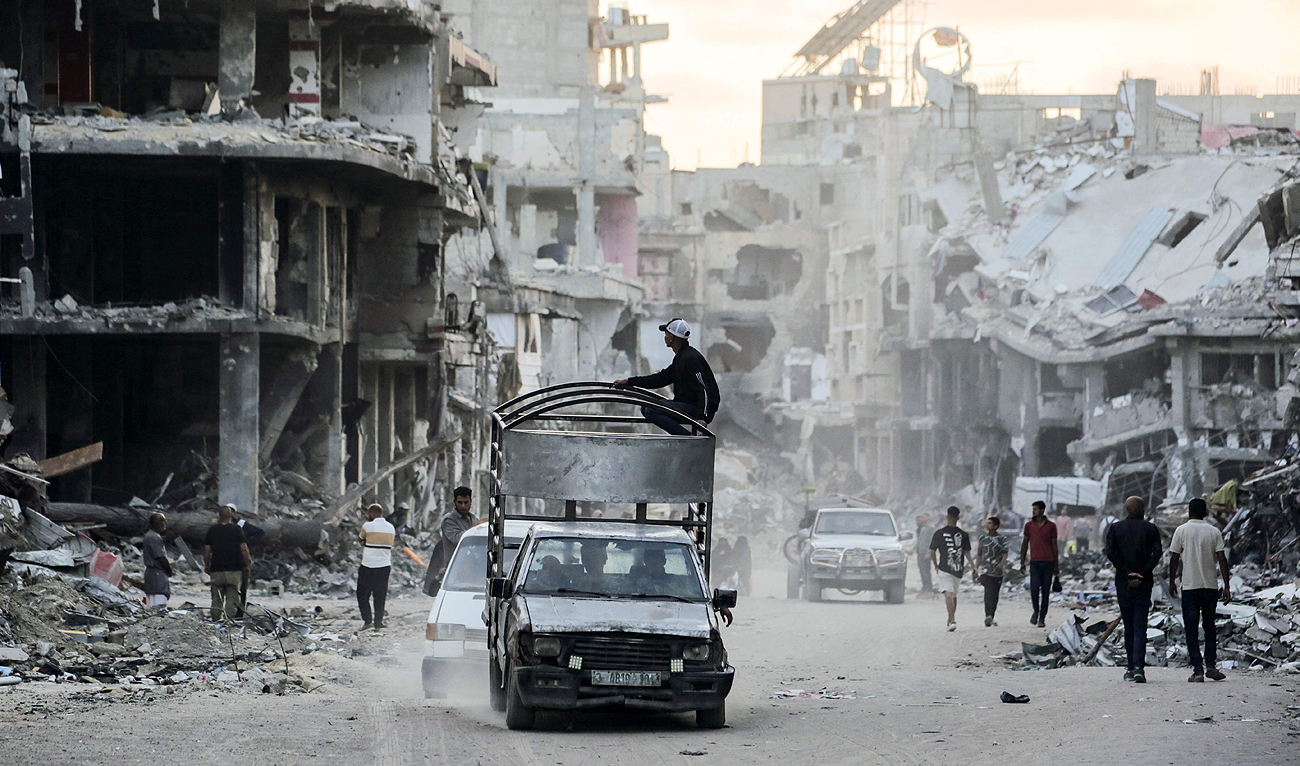 Displaced Palestinians drive their vehicles along a street devastated by Israeli bombardment in Khan Yunis in the southern Gaza Strip on May 15, 2024, amid the ongoing conflict between Israel and the Hamas group. (AFP)