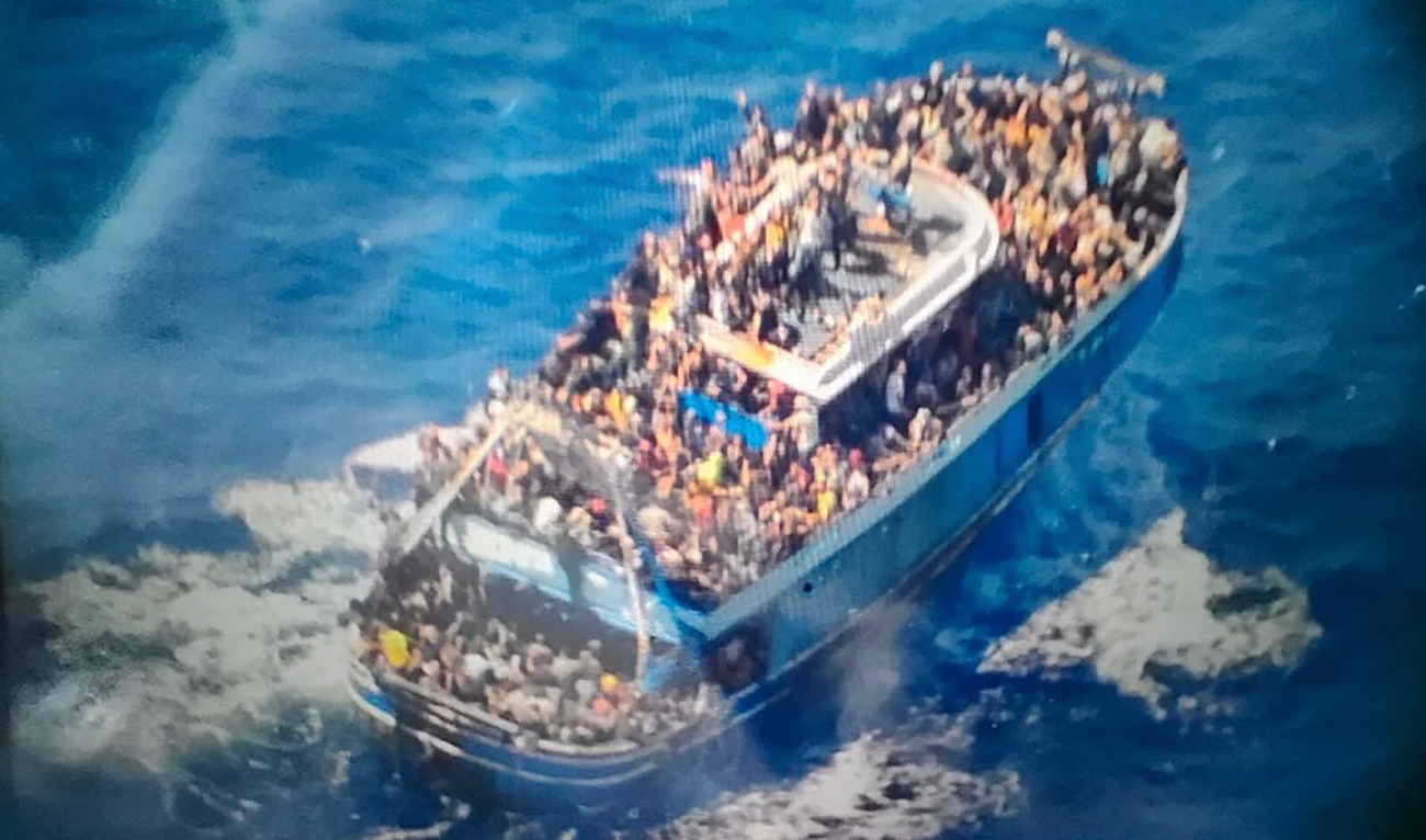 n this undated handout provided by Greece's coast guard on Wednesday, June 14, 2023, scores of people sit on a battered fishing boat that later capsized and sank off southern Greece. ((Hellenic Coast Guard via AP/File)