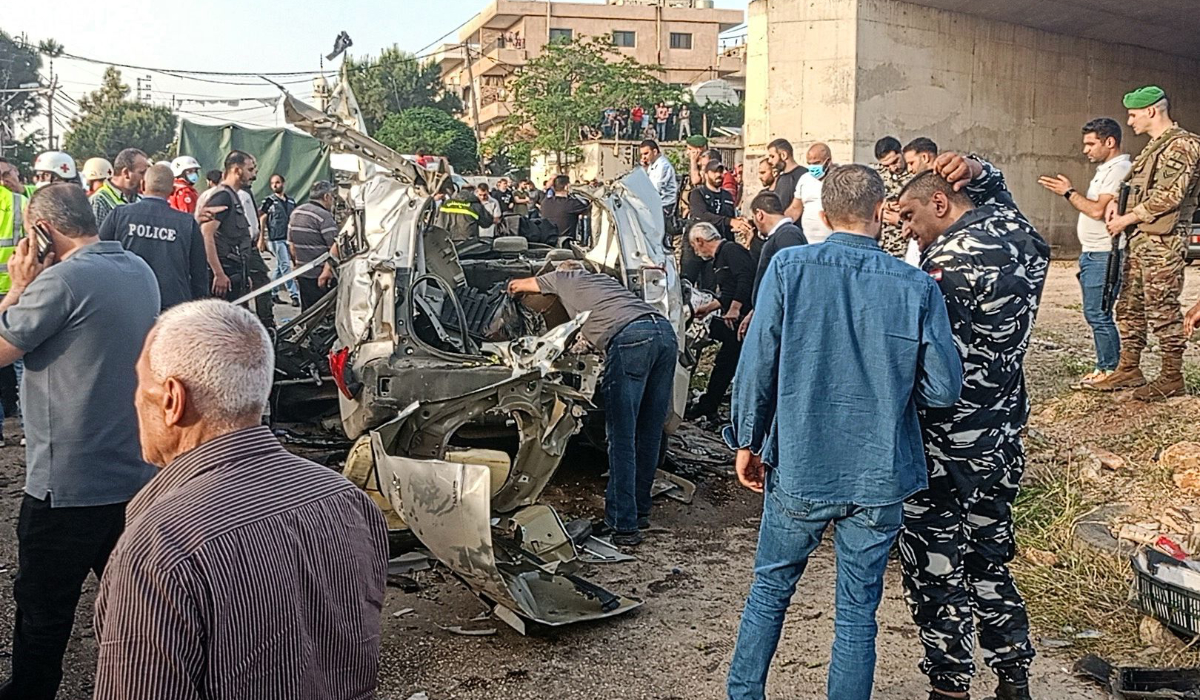 Lebanese army soldiers and onlookers gather around the carcasses of a car after it was hit by an Israeli strike, reportedly killing a local Hamas official, in Majd al-Jabal in Lebanon's Bekaa valley, on May 17, 2024. (AFP)