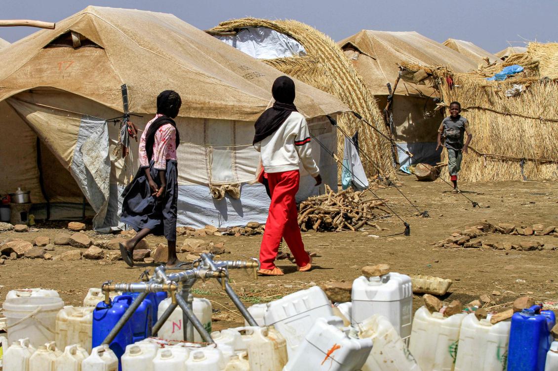 Girls walk past tents at a camp for people displaced by conflict in Sudan’s eastern Gedaref province on May 15, 2024. (AFP)