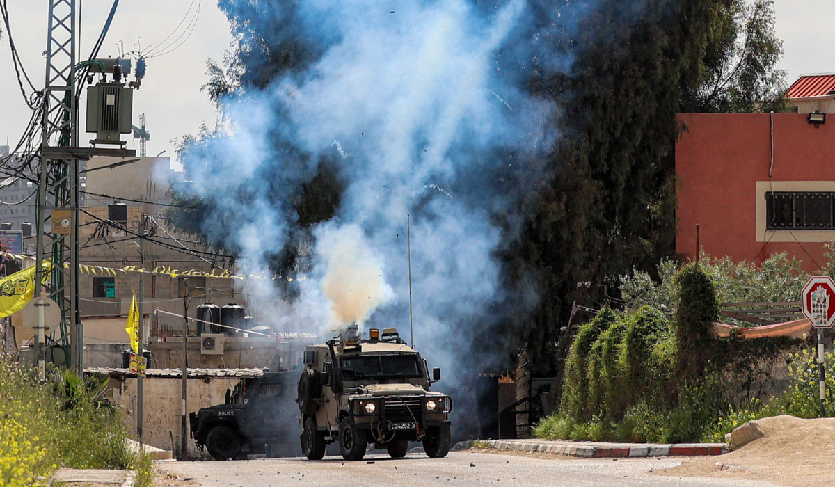 Tear gas canisters are fired from an Israeli military vehicle near the Palestinian refugee camp of Jenin in the occupied West Bank on April 9, 2022. (AFP file photo)