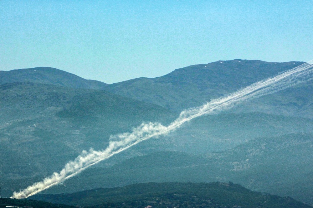 Rockets leave smoke trails behind as they are launched from southern Lebanon toward Israel. (AFP)