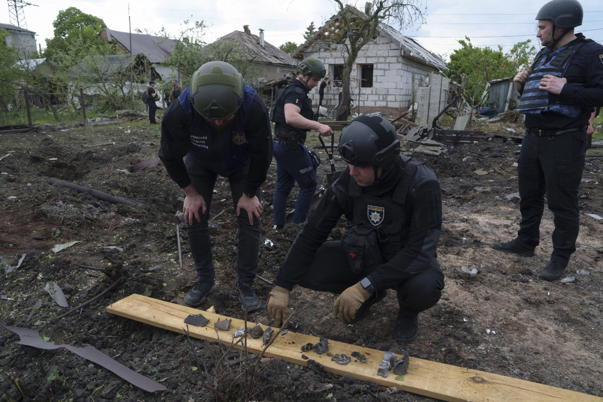 A Ukrainian police officer and war crime prosecutor inspect fragments of a glide bomb in front of damaged house, after a Russian airstrike on a residential neighborhood in Kharkiv, Ukraine, on May 18, 2024. (AP)