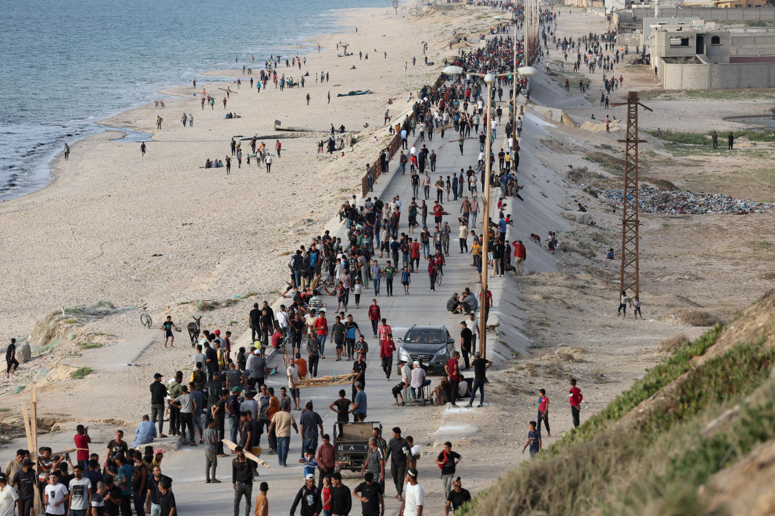 Palestinians gather in the hope of obtaining aid delivered into Gaza through a US-built pier, amid the ongoing conflict between Israel and the Palestinian Islamist group Hamas, as seen from central Gaza Strip, May 19, 2024. (Reuters)