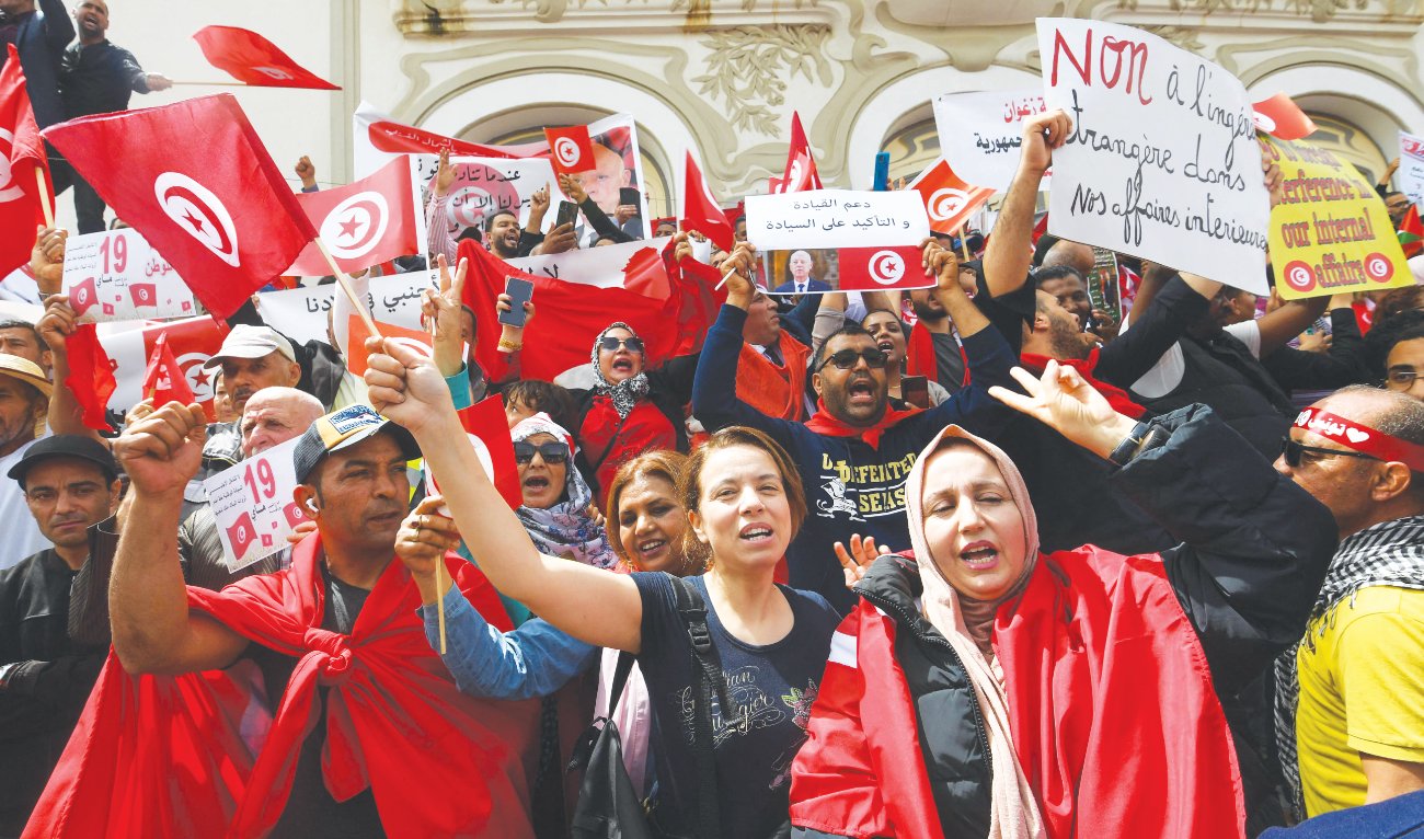 Supporters of Tunisia’s President Kais Saied chant pro-government slogans, rejecting foreign interference in the country’s internal affairs, during a rally in Tunis on Sunday. (AFP)