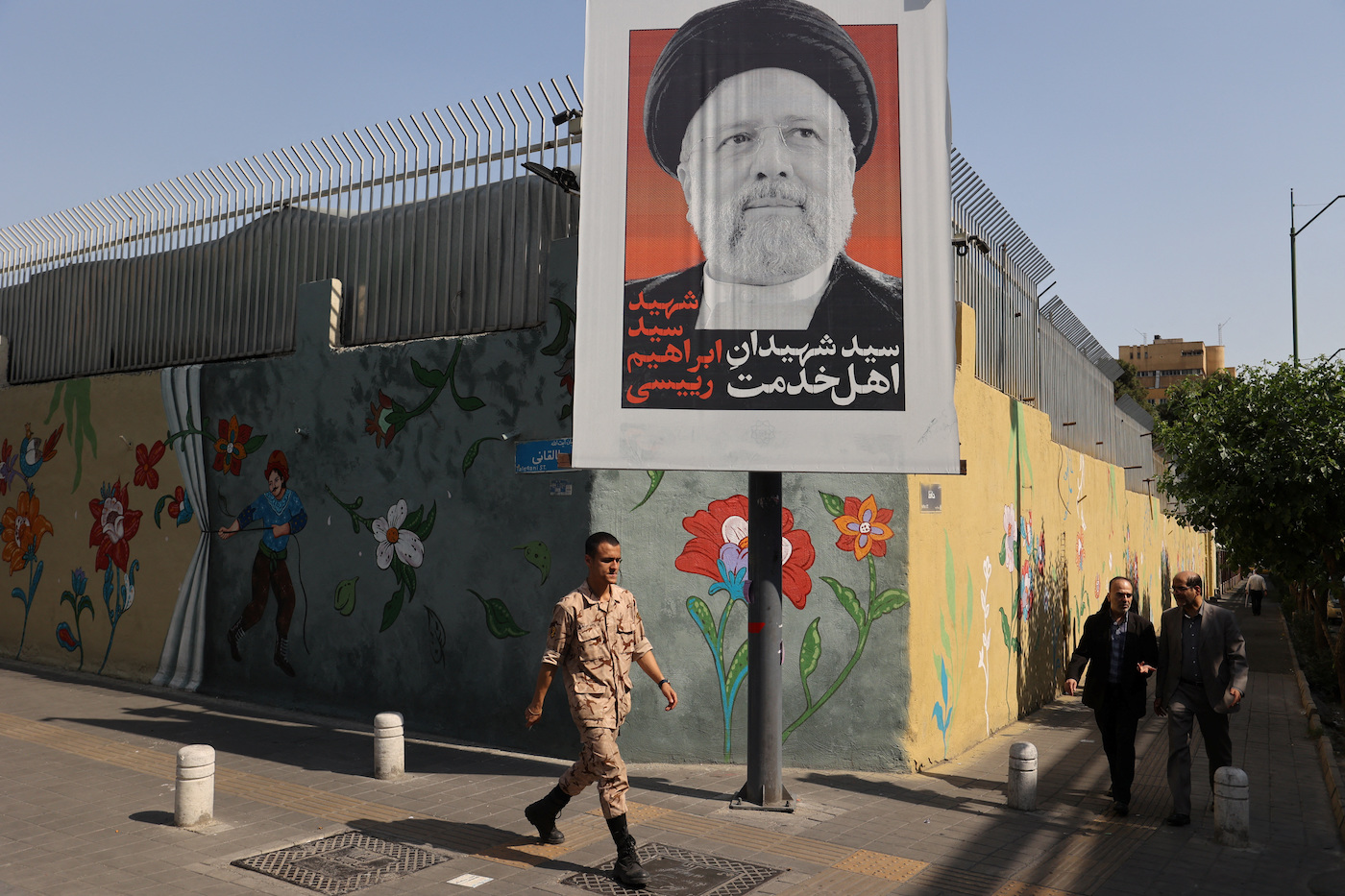 A person walks past a banner with a picture of the late Iran’s President Ebrahim Raisi on a street in Tehran, Iran May 20, 2024. (Reuters)