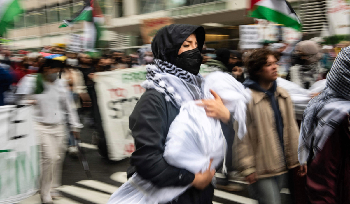 A pro-Palestinian protester holds a mock body as she marches from Philadelphia City Hall to University of Drexel Campus where they set up an encampment as they rally to mark the Nakba anniversary in Philadeplphia, Pennsylvania on May 18, 2024. (AFP)
