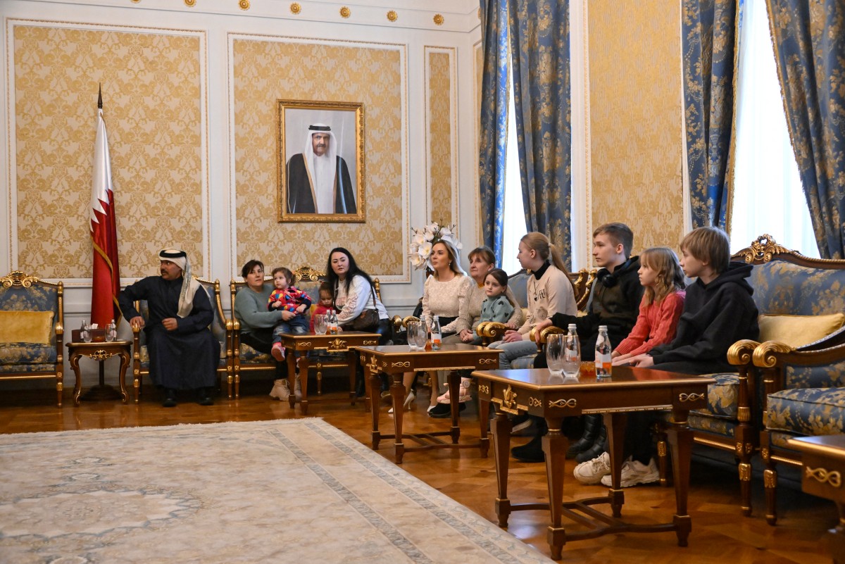 Russia's presidential commissioner for children's rights Maria Lvova-Belova (C) sits with Ukrainian children before their departure to Ukraine from Russia under a deal brokered by Qatar, at the Qatari embassy in Moscow on February 19, 2024