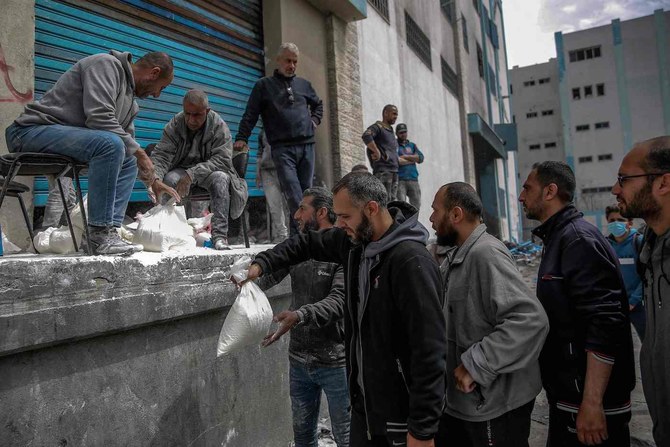 A man hands out bags of flour during the distribution of humanitarian aid in Gaza City on March 17, 2024. (AFP/File)
