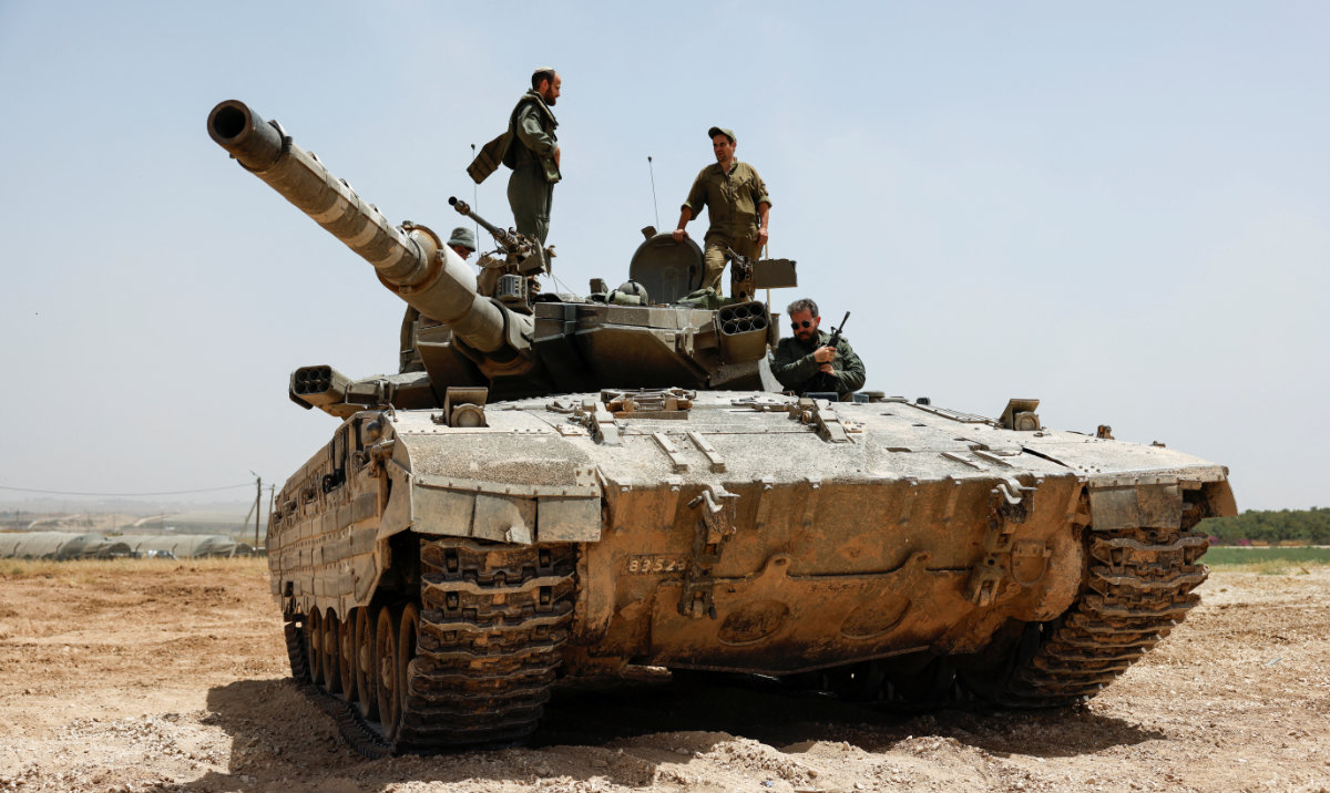 Israeli soldiers operate atop a tank near the Israel-Gaza border, amid the ongoing conflict between Israel and the Palestinian Islamist group Hamas, as seen from Israel, May 21, 2024. (Reuters)