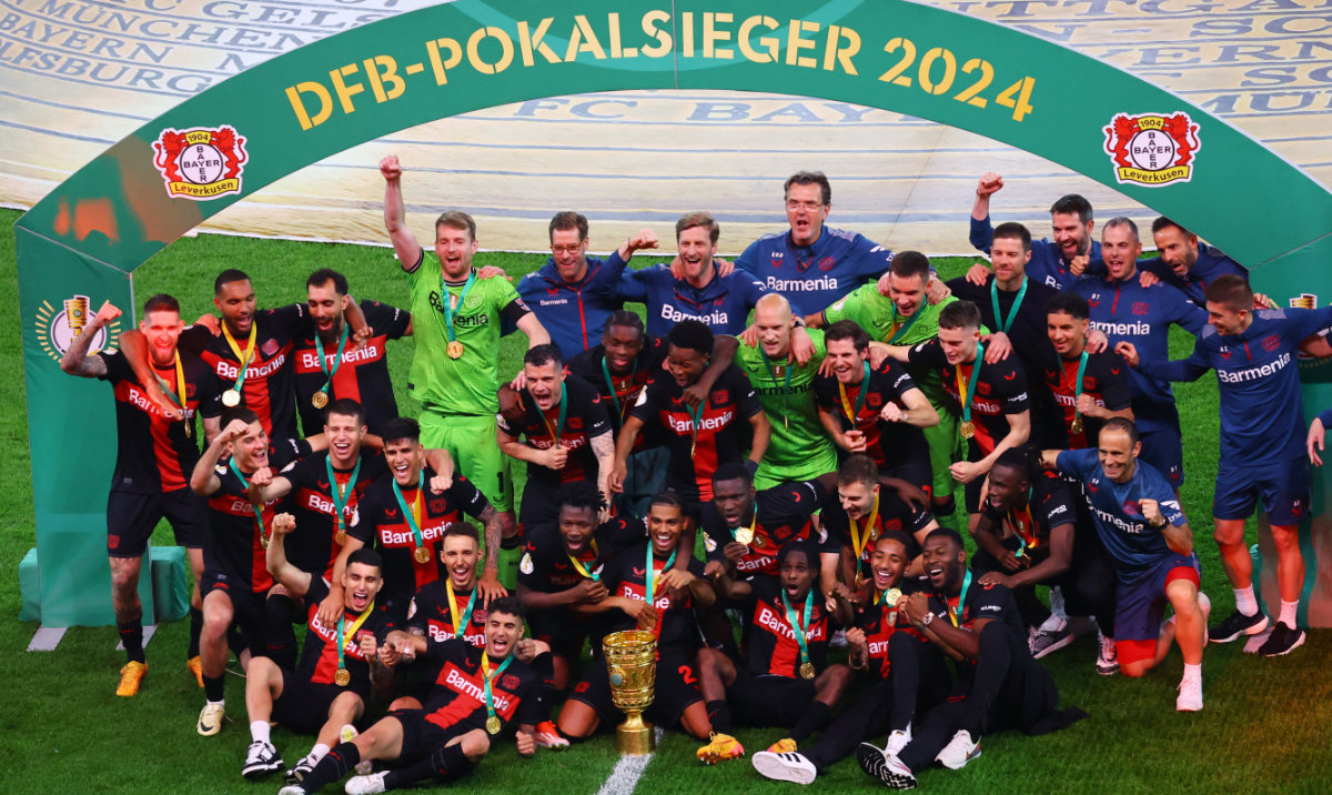 Bayer Leverkusen players pose for a picture with the trophy after winning the German Cup to complete an undefeated domestic double on Saturday. (Reuters)
