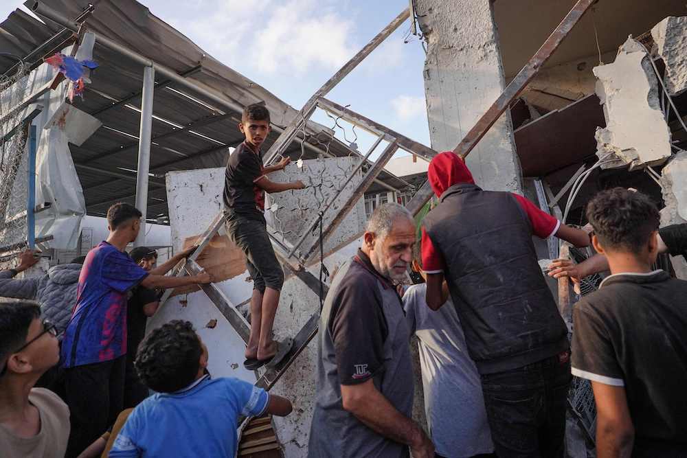 Palestinians inspect the aftermath of an Israeli strike on a building in Nuseirat on May 25, 2024, amid continuing battles between Israel and Hamas in the Gaza Strip. (AFP)