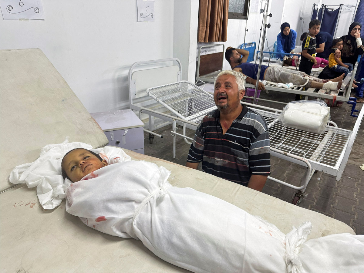 A man reacts next to the body of a Palestinian child killed in an Israeli strike on an area designated for displaced people in Rafah on May 26, 2024. (REUTERS)
