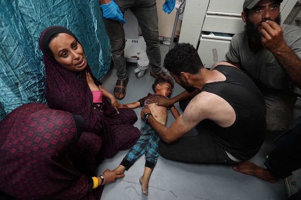 The mother of a Palestinian toddler weeps as attempts to save his life continue at the Al-Aqsa Martyrs Hospital in the central Gaza Strip after he was badly injured in Israeli bombardment on May 27, 2024. (AFP)