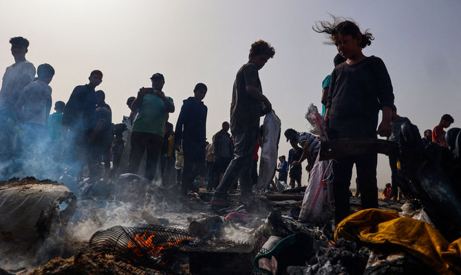 Palestinians gather at the site of an Israeli strike on a camp area housing internally displaced people in Rafah on May 27, 2024, amid ongoing battles between Israel and the Palestinian Hamas militant group. (AFP)