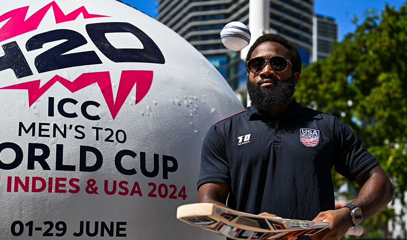 US Cricket Vice-Captain Aaron Jones taps a ball with a bat next to a giant cricket ball installed at a marketplace to mark 100 days to go for the ICC Men’s T20 World Cup in Miami, Florida, on February 22, 2024. (AFP)