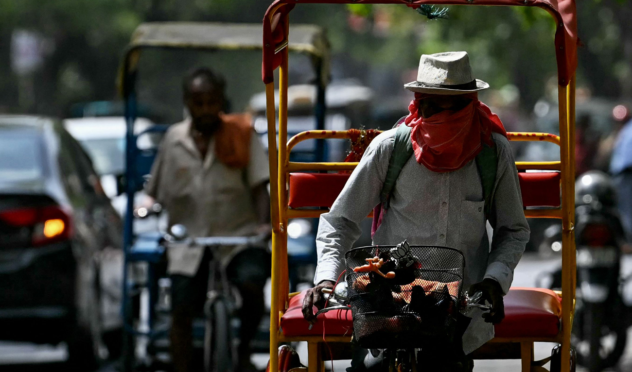 A rickshaw puller covers his face with cloth on a hot summer afternoon in New Delhi on May 29, 2024, amid ongoing heat wave. (AFP)