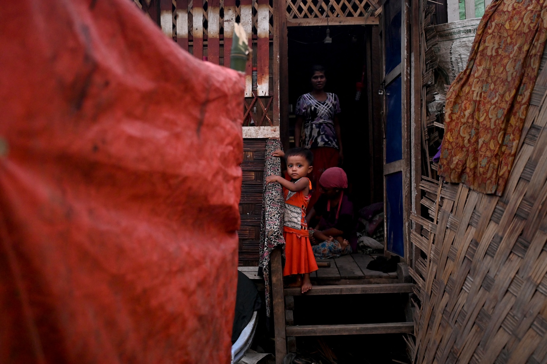 A child stands on the door foot of her house at the Khaung Dote Khar Rohingya refugee camp in Sittwe, on May 15, 2023. (AFP)