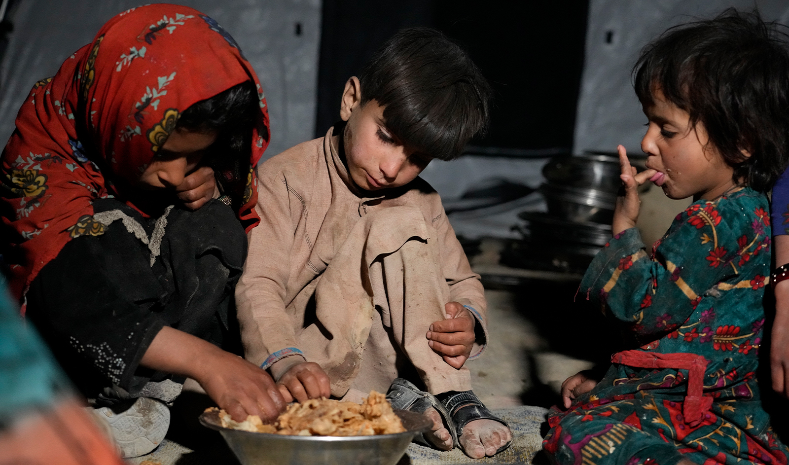 Afghan children eat in a makeshift shelter after an earthquake in Gayan district in Paktika province, Afghanistan, on June 25, 2022. (AP)