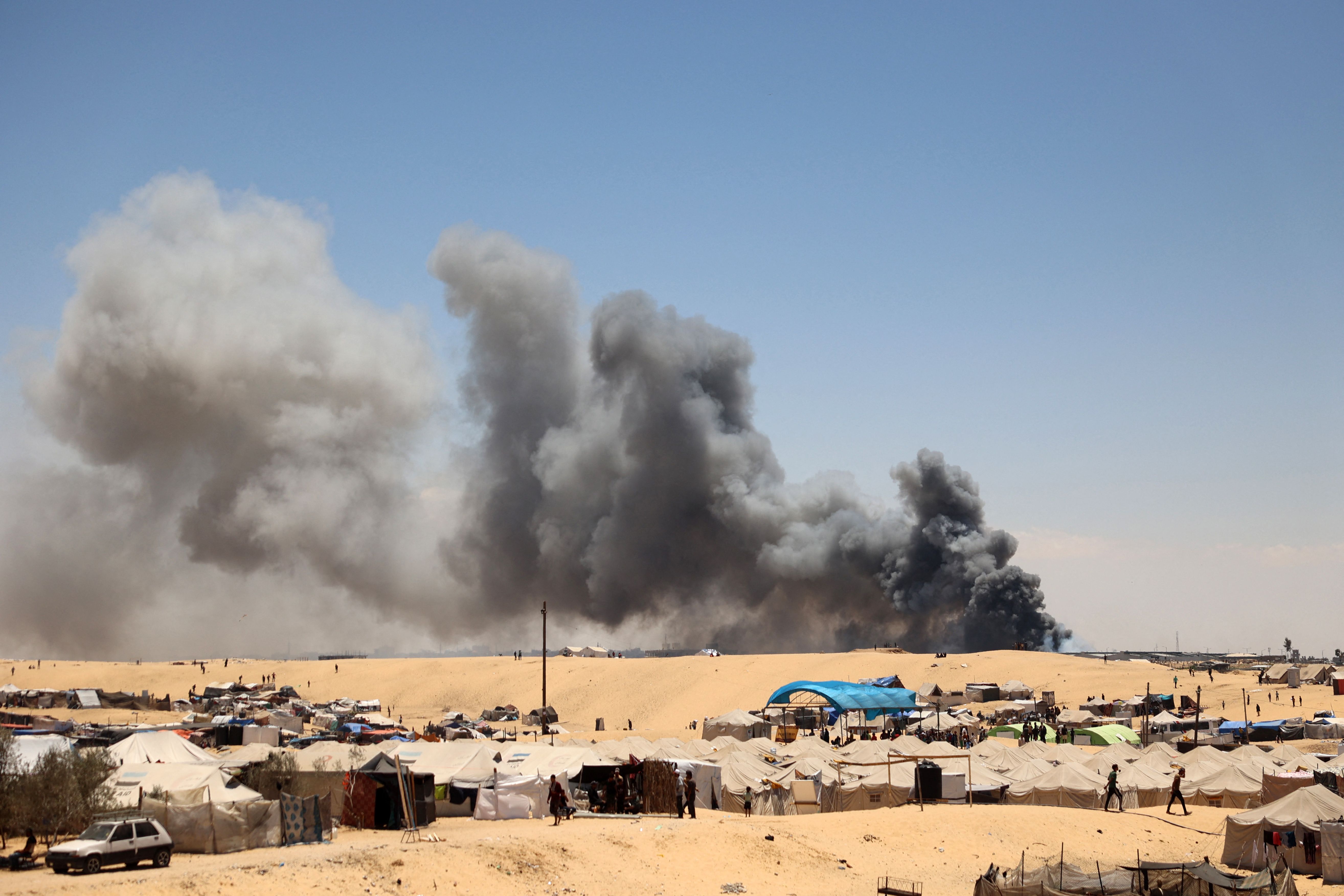 Smoke rises near a makeshift camp for displaced Palestinians in the area of Tel al-Sultan in Rafah in the southern Gaza Strip on May 30, 2024, amid the ongoing conflict between Israel and the militant group Hamas. (AFP)