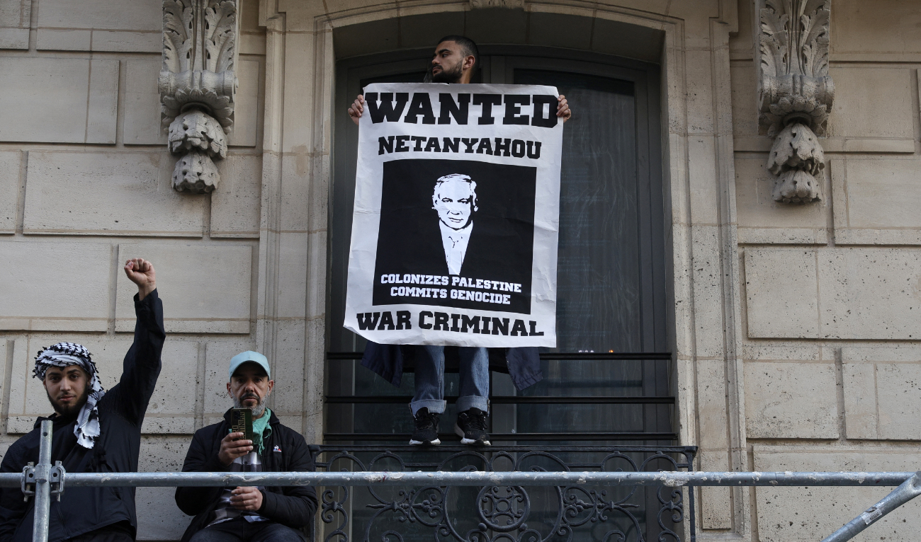 A protestor holds a poster bearing a wanted announcement for Israeli Prime Minister Benjamin Netanyahu during a demonstration in Paris on May 27, 2024 to protest an overnight Israeli strike on a camp in Rafah for internally displaced Palestinians. (AFP/File)