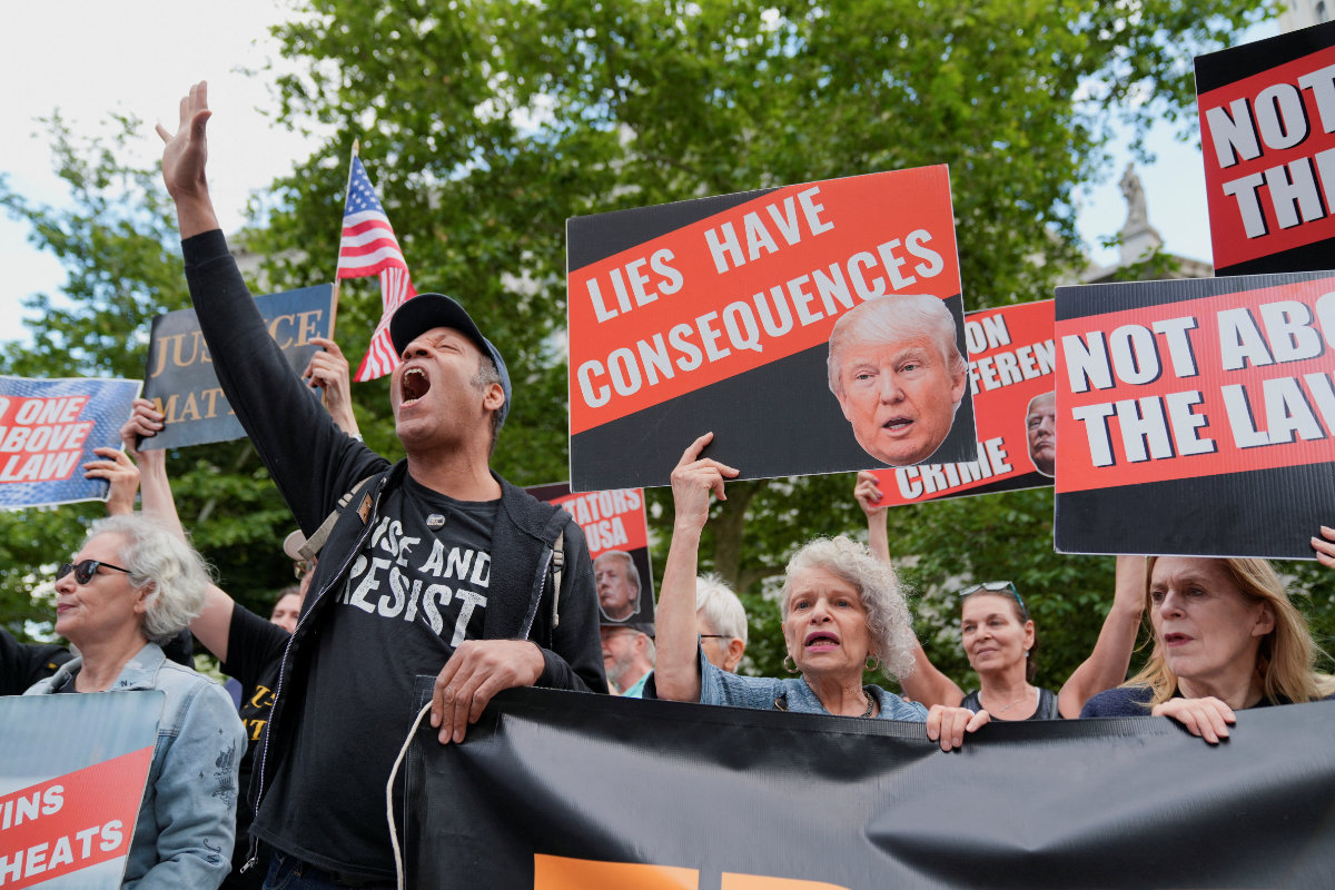 Demonstrators hold placards and flags outside the Manhattan criminal court in New York City on May 30, 2024, following the announcement of former US President Donald Trump's verdict in his criminal trial over charges that he falsified business records to conceal money paid to silence porn star Stormy Daniels in 2016. (REUTERS)