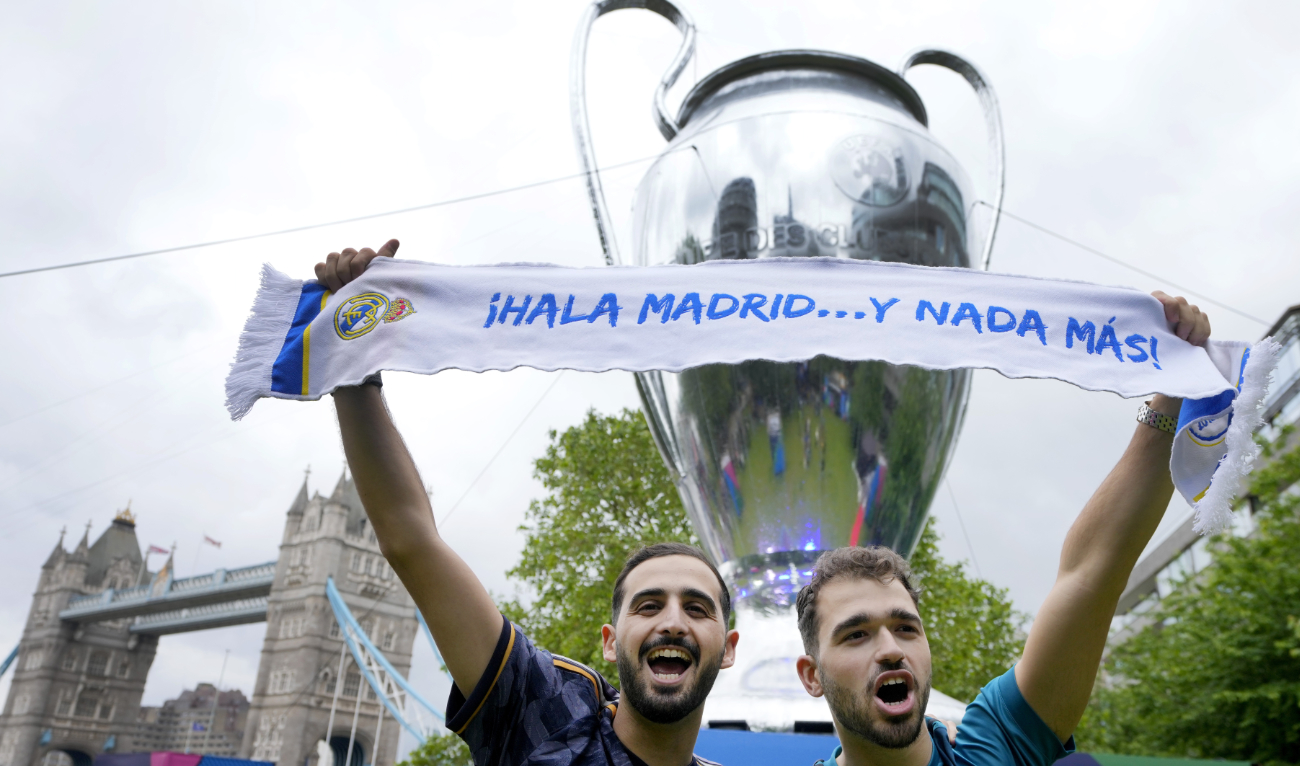 Football fans pose by a giant replica of the Champions League Trophy at the Champions Festival in Potters Fields Park near Tower Bridge in London Thursday. The Champions League final between Dortmund and Real Madrid takes place at Wembley Stadium on Saturday. (AP)