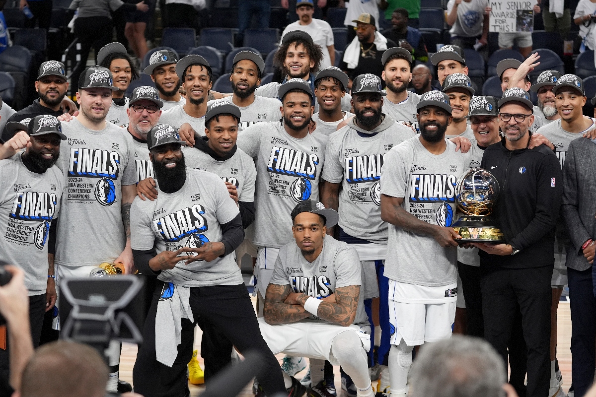 The Dallas Mavericks celebrate as they pose for a team photograph after Game 5 of the Western Conference finals in the NBA playoffs against the Minnesota Timberwolves, Thursday, in Minneapolis. The Mavericks won 124-103, taking the series 4-1 and moving on to the NBA Finals. (AP)