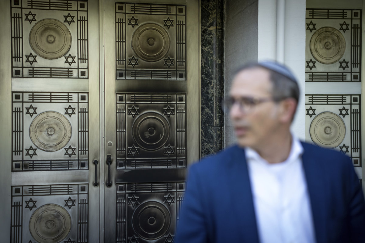 A metal plated on a door at the Schara Tzedeck synagogue is blackened as Rabbi Andrew Rosenblatt speaks to media on May 31, 2024, in Vancouver, British Columbia. (The Canadian Press via AP)