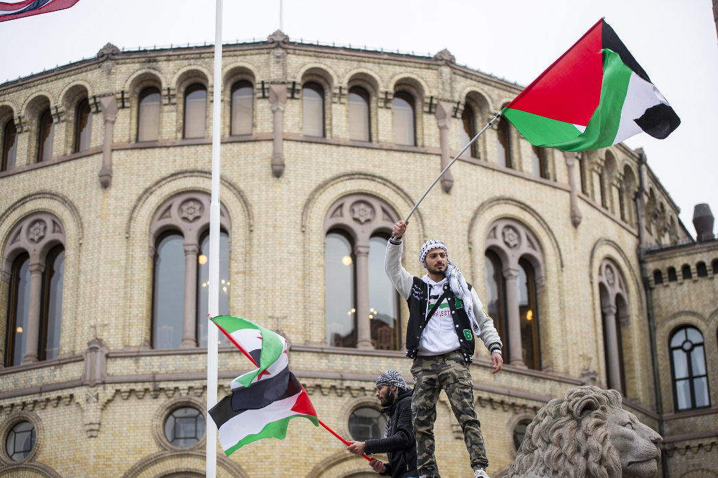 A man waves the Palestinian flag in front of the Norwegian Parliament building during a demonstration in Oslo. (AP)