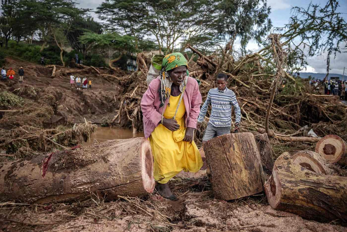 A woman walks in an area full of damaged trees, mud and debris carried by water following flash floods and landslides in Mai Mahiu, on April 30, 2024. (AFP)