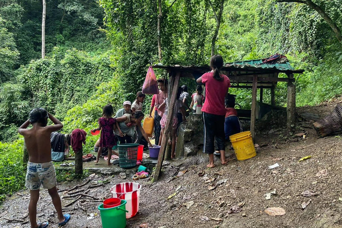 This picture taken on September 24, 2021 shows refugees collecting water at Pang village in India's eastern state of Mizoram near the Myanmar border, after people fled across the border following attacks by Myanmar's military on villages in western Chin state. (AFP)