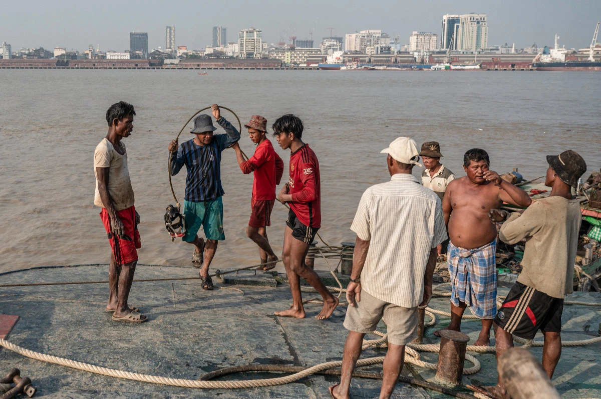 This photo taken on January 23, 2024 shows workers recovering a sunken ship in the Yangon River in Yangon. Myanmar's junta rulers have banned all males from seeking work abroad. (AFP)