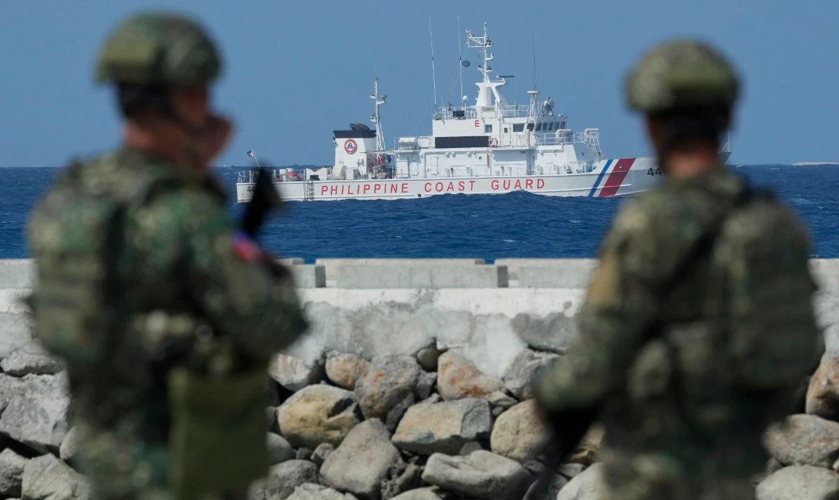 Philippine troops watches a Philippine coast guard ship as they secure an area at the Philippine-occupied Thitu island, locally called Pag-asa island, on Dec. 1, 2023 at the disputed South China Sea. For the first time, China has publicized what it claims is an unwritten 2016 agreement with the Philippines over access to South China Sea islands. (AP/File)