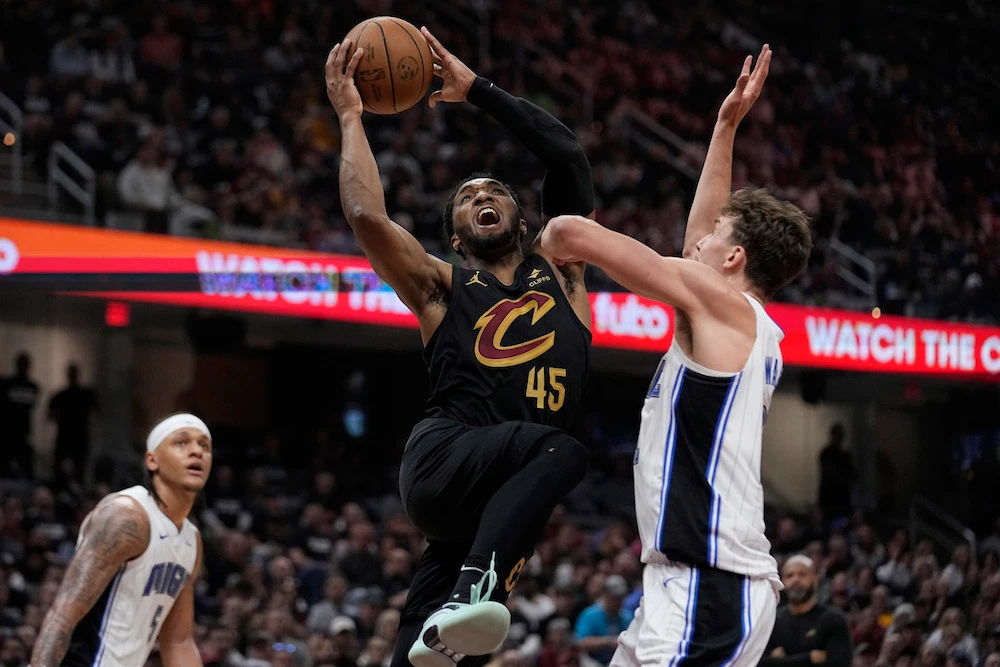Cleveland Cavaliers guard Donovan Mitchell shoots between Orlando Magic’s Paolo Banchero and Wagner in the first half of Game 7 of an NBA basketball first-round playoff series Sunday in Cleveland. (AP)
