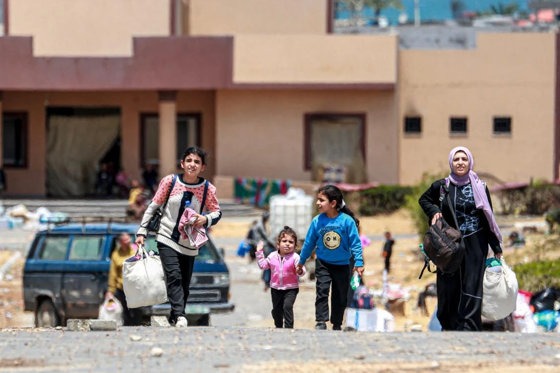 Displaced Palestinians who left with their belongings from Rafah in the southern Gaza Strip following an evacuation order by the Israeli army, arrive to Khan Yunis on May 6, 2024. (AFP)