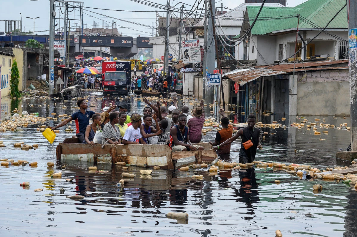People cross the floodwater of the Carrigrès bridge in a pirogue in the Pompage district in Kinshasa on January 9, 2024 following heavy rains and the flood of the Congo River. Unusually heavier rainfall prompted by climate change has forced rivers and lakes in the central African country to overflow, swallowing towns, villages and roads on the shores. (AFP)