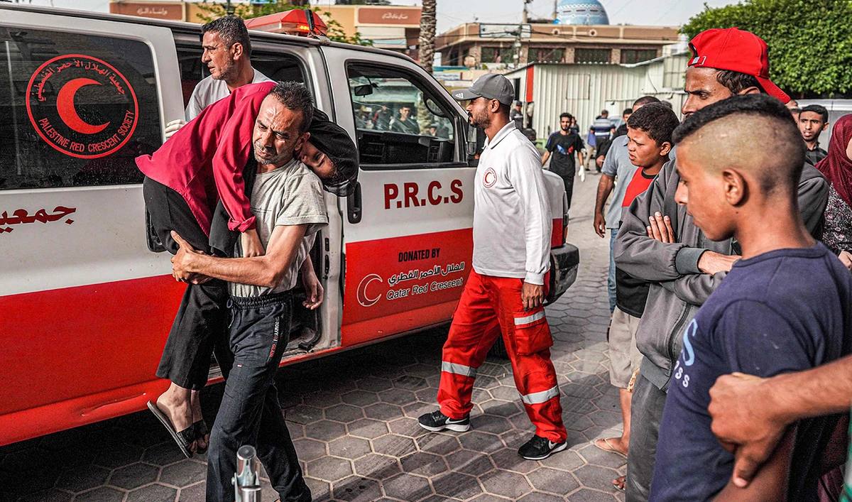 A man carries an injured child into the Aqsa Martyrs Hospital in Deir el-Balah in the central Gaza Strip on May 11, 2024 amid the ongoing conflict in the Palestinian territory between Israel and Hamas. (AFP)