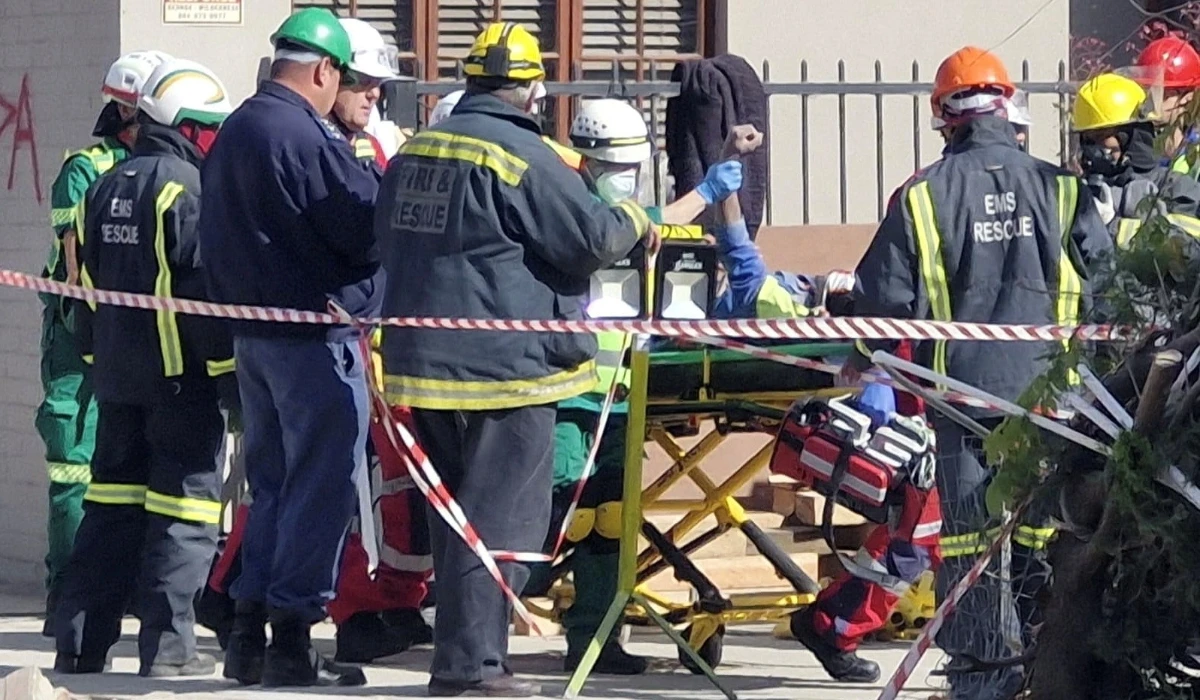 A man raises his hand as rescue workers carry him to an ambulance after being rescued having survived 118 hours after a deadly building collapse in George, South Africa May 11, 2024. (REUTERS)