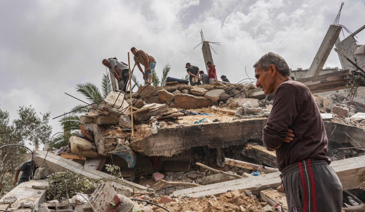 Palestinians check the rubble of a residential building destroyed in an Israeli strike in Al-Zawayda in the central Gaza Strip on May 11, 2024, amid the ongoing conflict between Israel and the Hamas movement. (AFP)