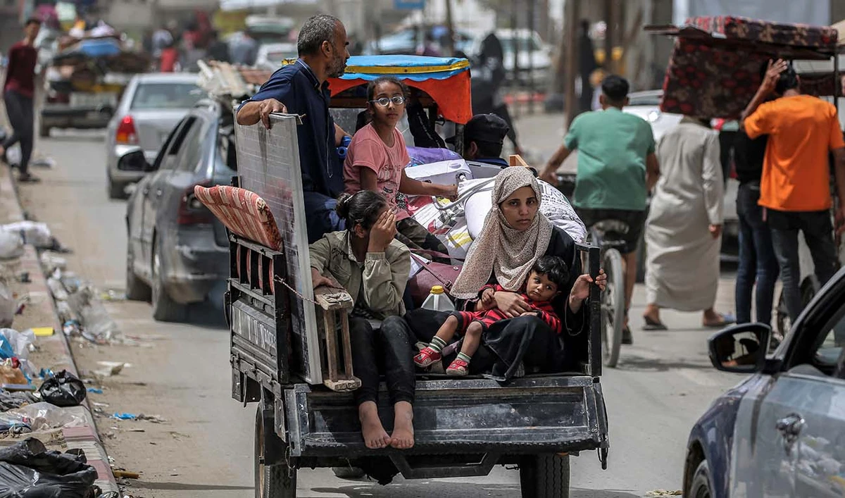 A man, woman, and children ride in the back of a tricycle loaded with belongings and other items as they flee bound for Khan Yunis, in Rafah in the southern Gaza Strip on May 11, 2024 amid the ongoing conflict in the Palestinian territory between Israel and Hamas. (AFP)