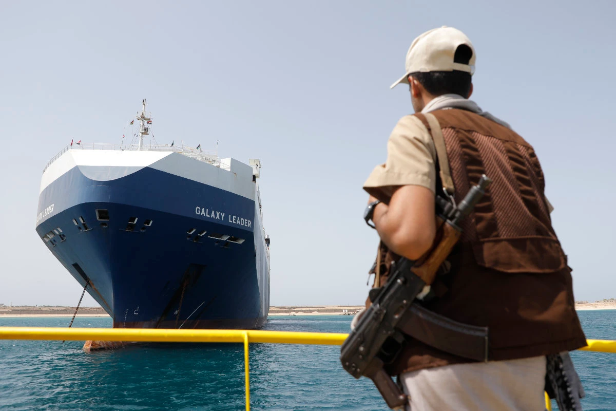 A Houthi soldier stands guard on May 12, 2024, in front of the Israeli Galaxy ship — which was seized late last year by the Yemeni militia — in the port of Saleef, near Hodeidah, Yemen. The Houthis have escalated their attacks on ships linked Israel that pass through the Al-Mandab Strait. (AP Photo)